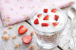 Muesli with cream and strawberry on wooden table