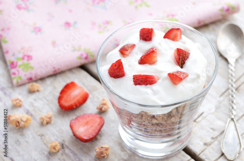 Photo: Muesli with cream and strawberry on wooden table Muesli with cream and strawberry on wooden table