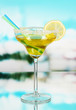 Yellow cocktail in glass on blue natural background