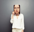Photo: woman covering image with big pensive face woman covering image with big pensive face