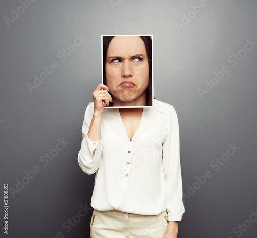 Photo: woman covering image with big pensive face woman covering image with big pensive face