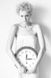 Scrawny girl with big clock in hands, black and white photo.