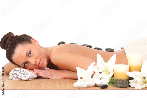 Photo: Beautiful relaxing woman with stones on her back in a Spa Beautiful relaxing woman with stones on her back in a Spa