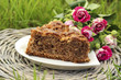 Piece of chocolate cake at garden party. Beautiful lush pink ros