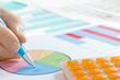 Photo: Hand with Pen and Calculator Analyzing Piechart Hand with Pen and Calculator Analyzing Piechart