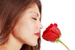 Close up of woman sniffing red rose with closed eyes