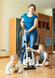 Happy mother wth two children cleans at home
