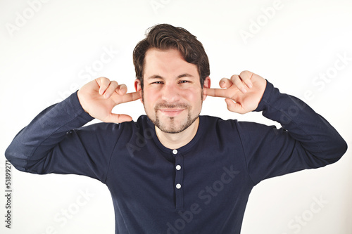 Photo: young man covering ears from loud noise, isolated on white backg young man covering ears from loud noise, isolated on white backg