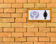 Restroom sign on brick wall