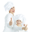 Mother and child having fun in the kitchen, show thumbs up