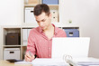 Foto: Junger Mann arbeitet am Computer im Büro Junger Mann arbeitet am Computer im Büro