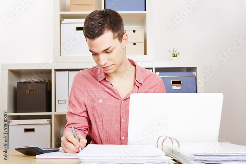 Photo: Junger Mann arbeitet am Computer im Büro Junger Mann arbeitet am Computer im Büro