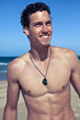 Fashion portrait of a young fit man on the beach