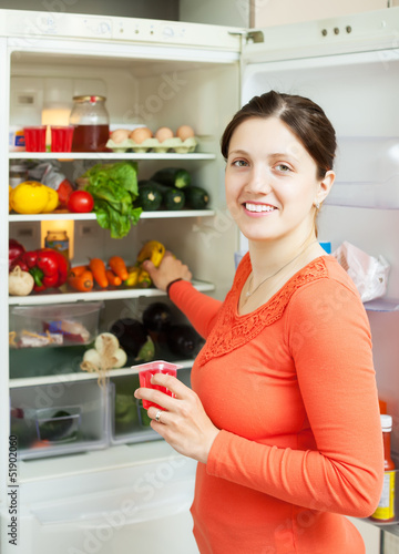 Photo: Happy woman looking for something in fridge Happy woman looking for something in fridge
