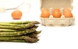 Asparagus and eggs on white background