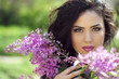 Young brunette woman with lilac flowers, Outdoors portrait