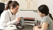 Female doc explaining something in tablet to patient