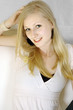 Hübsche blonde junge Frau auf Sofa