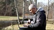 Man with cell phone and  PC on a bench in the park