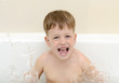 The boy splashes in a bathroom