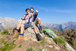 Young Couple with Thumbs Up at Top of Mountain