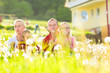 Photo: family sitting in meadow in front of home family sitting in meadow in front of home