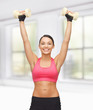 young sporty woman with light dumbbells