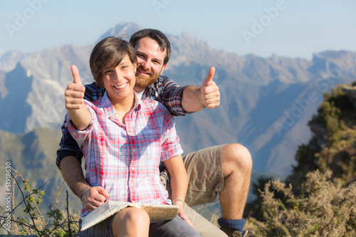 Photo: Young Couple with Thumbs Up at Top of Mountain Young Couple with Thumbs Up at Top of Mountain