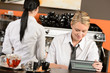 Happy waitresses working at cafe in uniform
