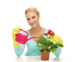 housewife with flower in pot and watering can