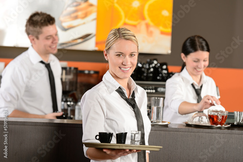 Photo: Confident waitress serving coffee with tray Confident waitress serving coffee with tray