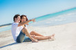 Photo: Young Couple Sitting in a Caribbean Beach Young Couple Sitting in a Caribbean Beach