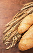 Foto: ears of cereals and rich bread on a wooden table ears of cereals and rich bread on a wooden table