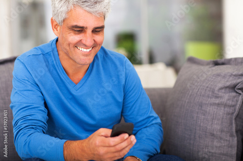 Photo: middle aged man reading emails on smart phone middle aged man reading emails on smart phone