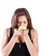 Beautiful brunette girl with closed eyes sniffs green apple