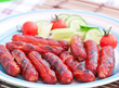 grilled sausages on the grill and a salad of fresh vegetables