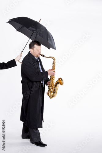 Photo: Saxophonist under an umbrella Saxophonist under an umbrella