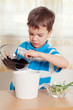 boy puts plant in pot