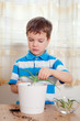boy puts plant in pot