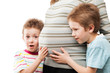 Two little sons touching or bonding their pregnant mother abdome