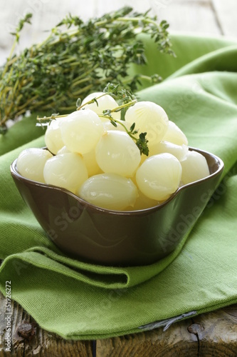 Photo: small pickled pearl onions on a wooden table small pickled pearl onions on a wooden table