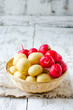 Fresh young potatoes and radishes in a basket