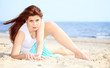 young woman on seacoast with shell on sand