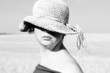 Pretty woman  in the hat in the field. Black and white photo.