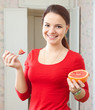 girl in red eats grapefruit