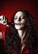 Horror shot: strange girl with mouth sewn shut cutting thread