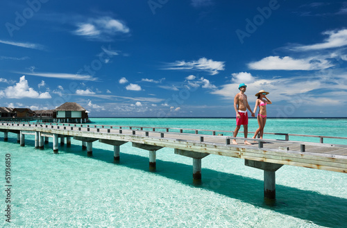 Photo: Couple on a beach jetty at Maldives Couple on a beach jetty at Maldives