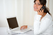 Young woman speaking on cellphone looking at you