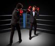 Two young businessman boxing