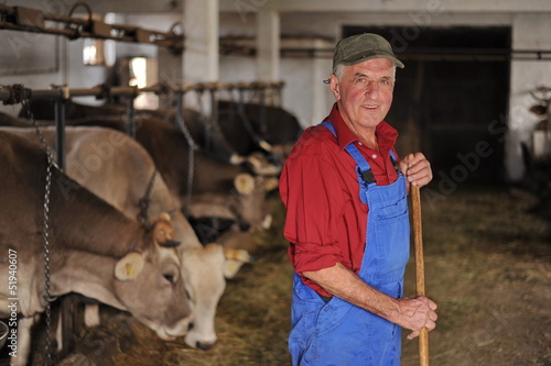 Photo: Farmer is working on a organic farm with cows Farmer is working on a organic farm with cows